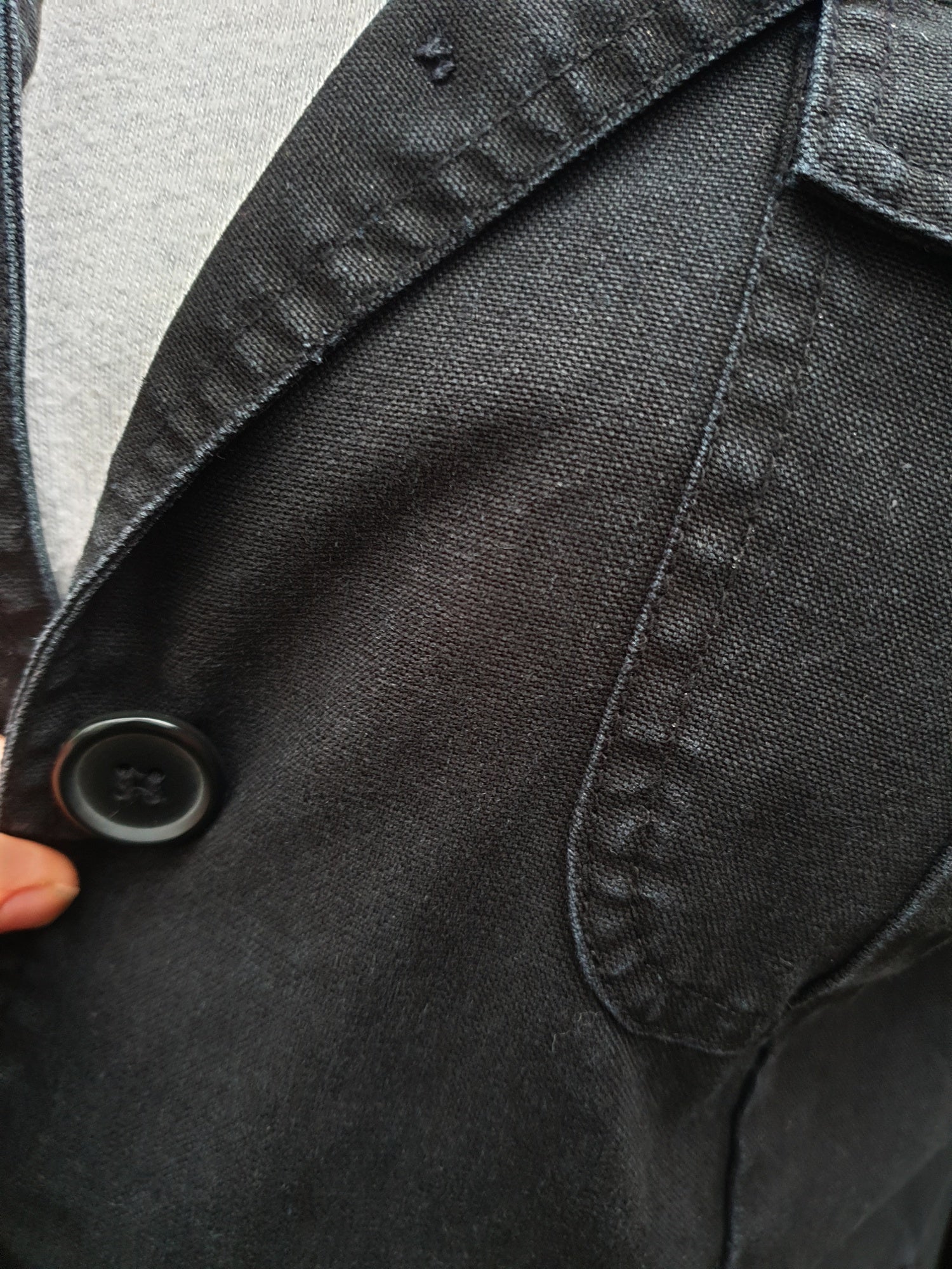 Close-up of the front pocket and stitching on the hand-painted cotton jacket.