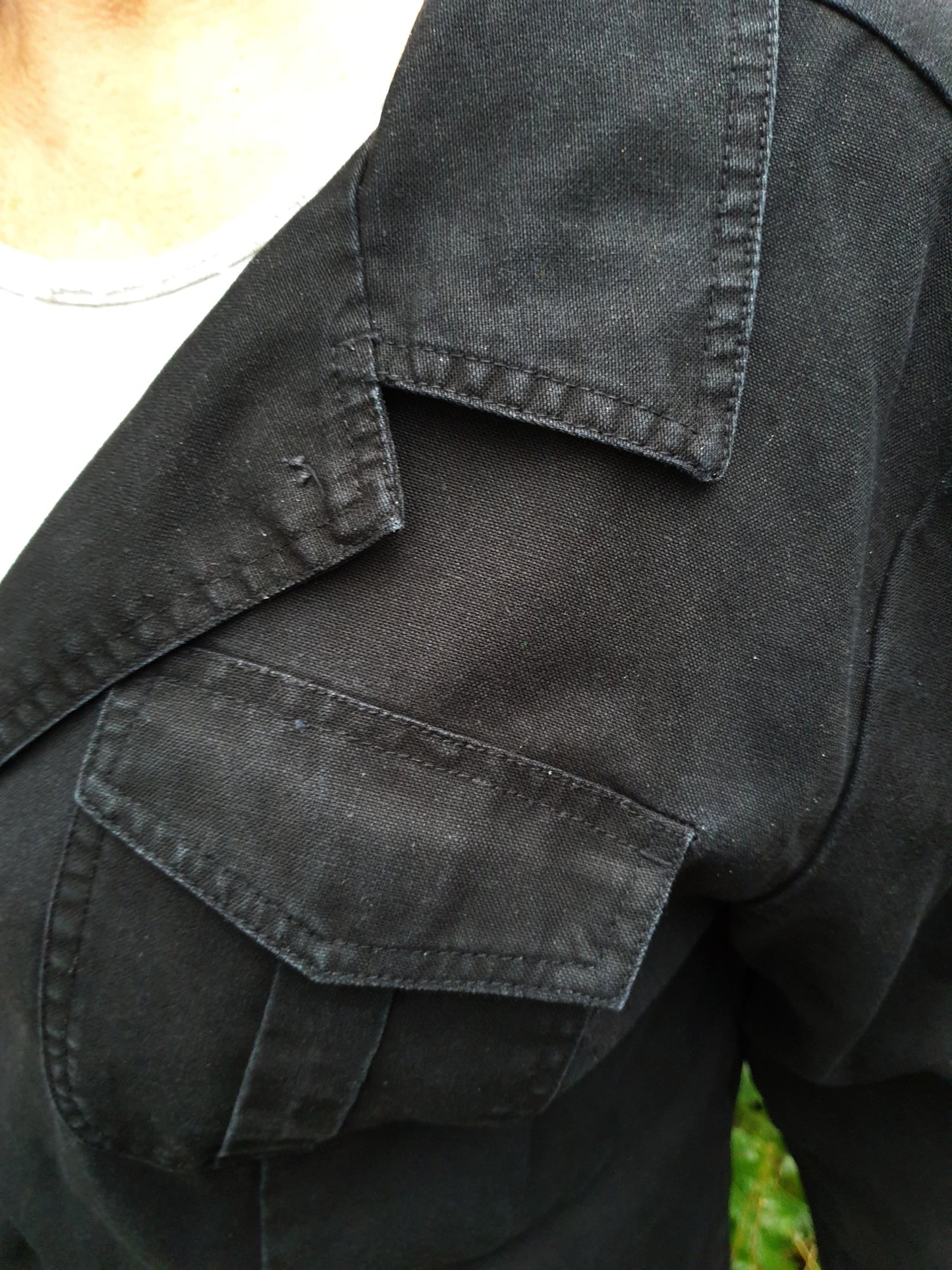 Close-up of the front pocket and stitching on the hand-painted cotton jacket.
