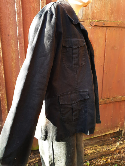 Side view of the black cotton jacket showing its boxy fit and mid-weight texture.