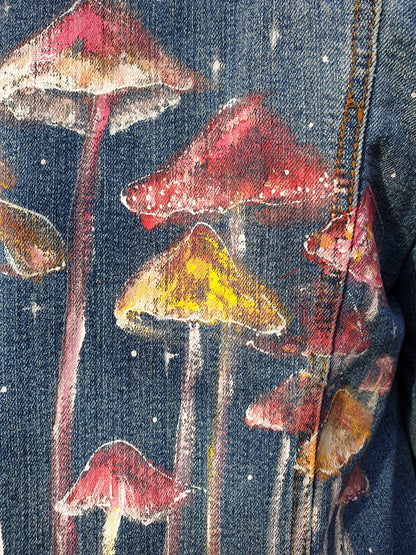 Close-up detail of hand-painted mushrooms on the sustainable upcycled denim jacket.