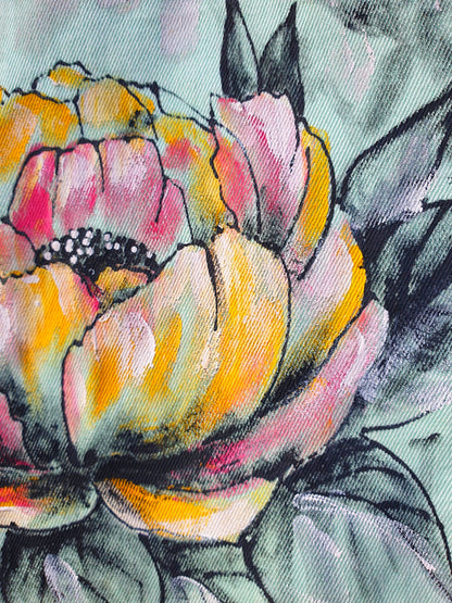 Close-up of the flower detail painted in pink, orange, and yellow tones on the back.