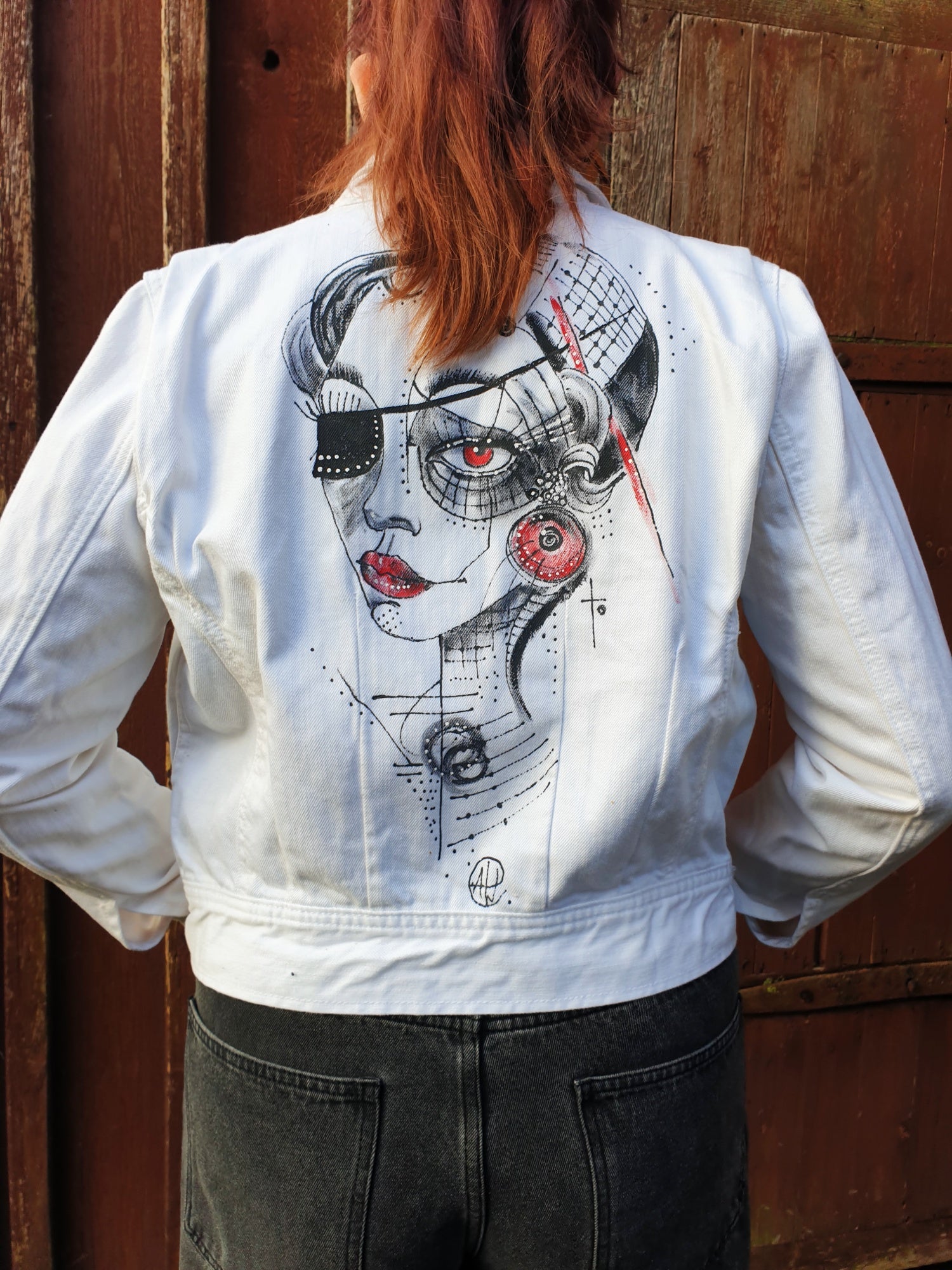 Back view of the “Red Signal” hand-painted white cotton jacket featuring a black and red portrait artwork.