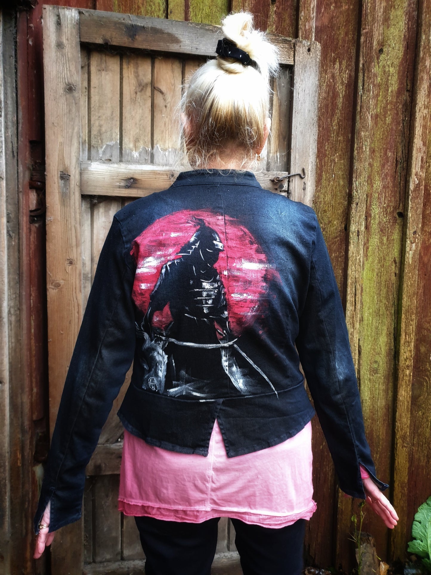Back view of the “Sunset Samurai” hand-painted deep navy denim jacket showing a samurai silhouette against a red sunset.