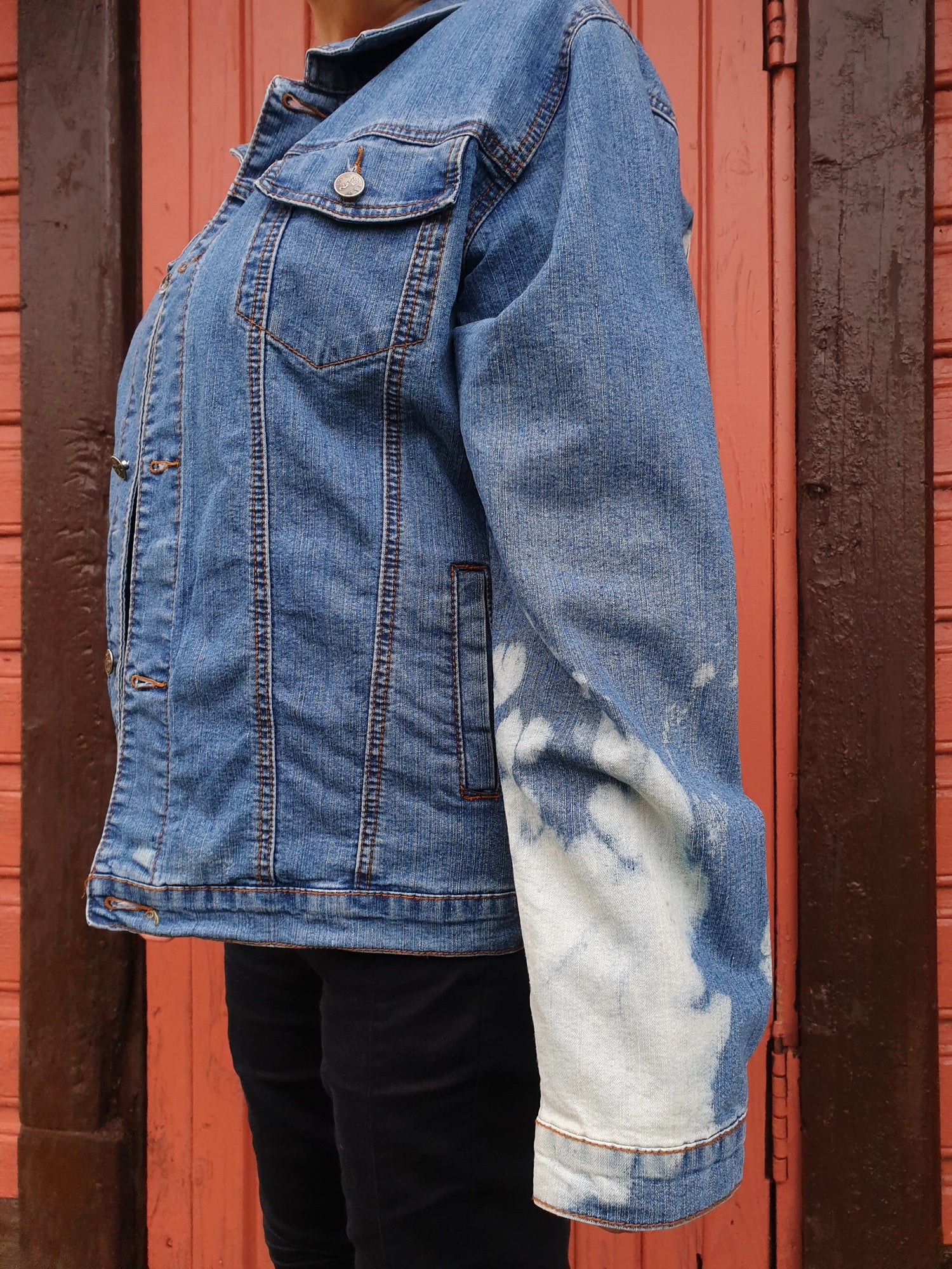 Close-up of the sleeve with soft white bleach clouds on light blue denim.