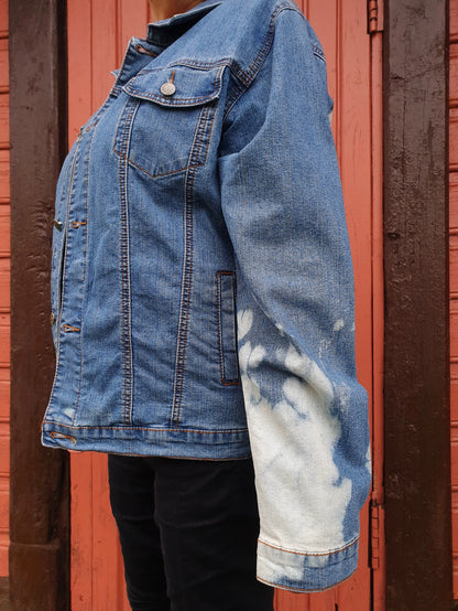 Close-up of the sleeve with soft white bleach clouds on light blue denim.