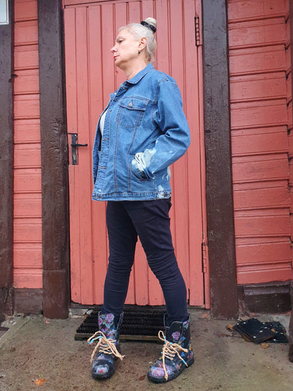 Model wearing the jacket in front of a rustic wooden wall, showing relaxed fit and texture.