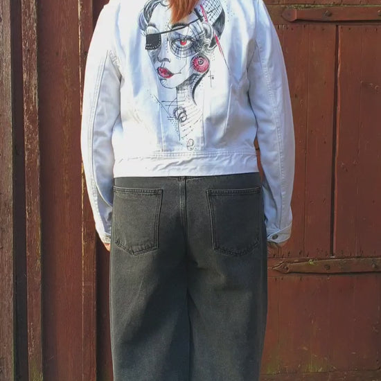 Close-up of the painted portrait in red and black tones with geometric details. Model view