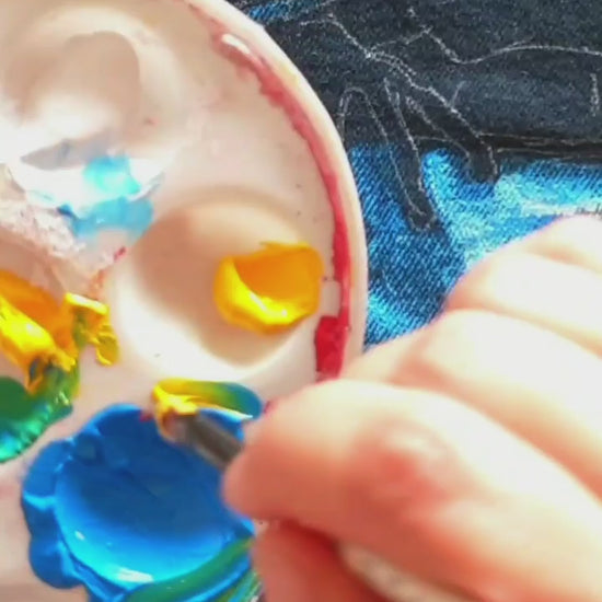 Painting process of the Space Frog Commander hand-painted upcycled denim jacket by Hele Artwear, capturing the creation of the cosmic frog artwork.