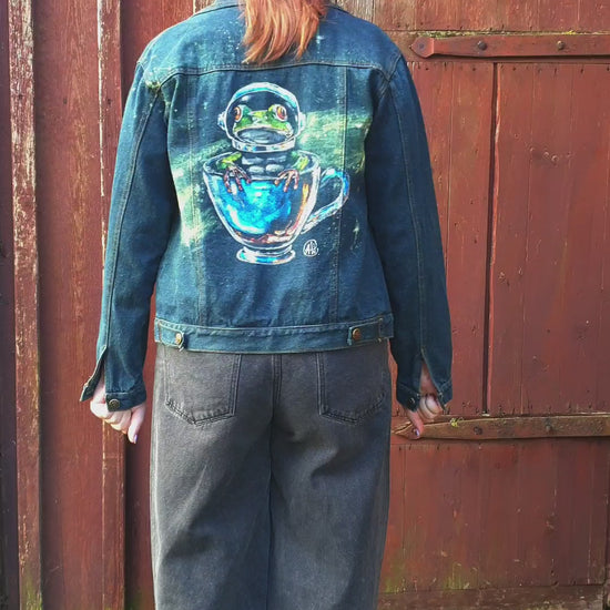 Model wearing the Space Frog Commander hand-painted upcycled denim jacket by Hele Artwear.
