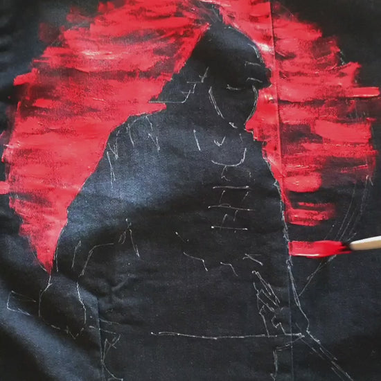 Painting  the “Sunset Samurai” hand-painted deep navy denim jacket showing a samurai silhouette against a red sunset.