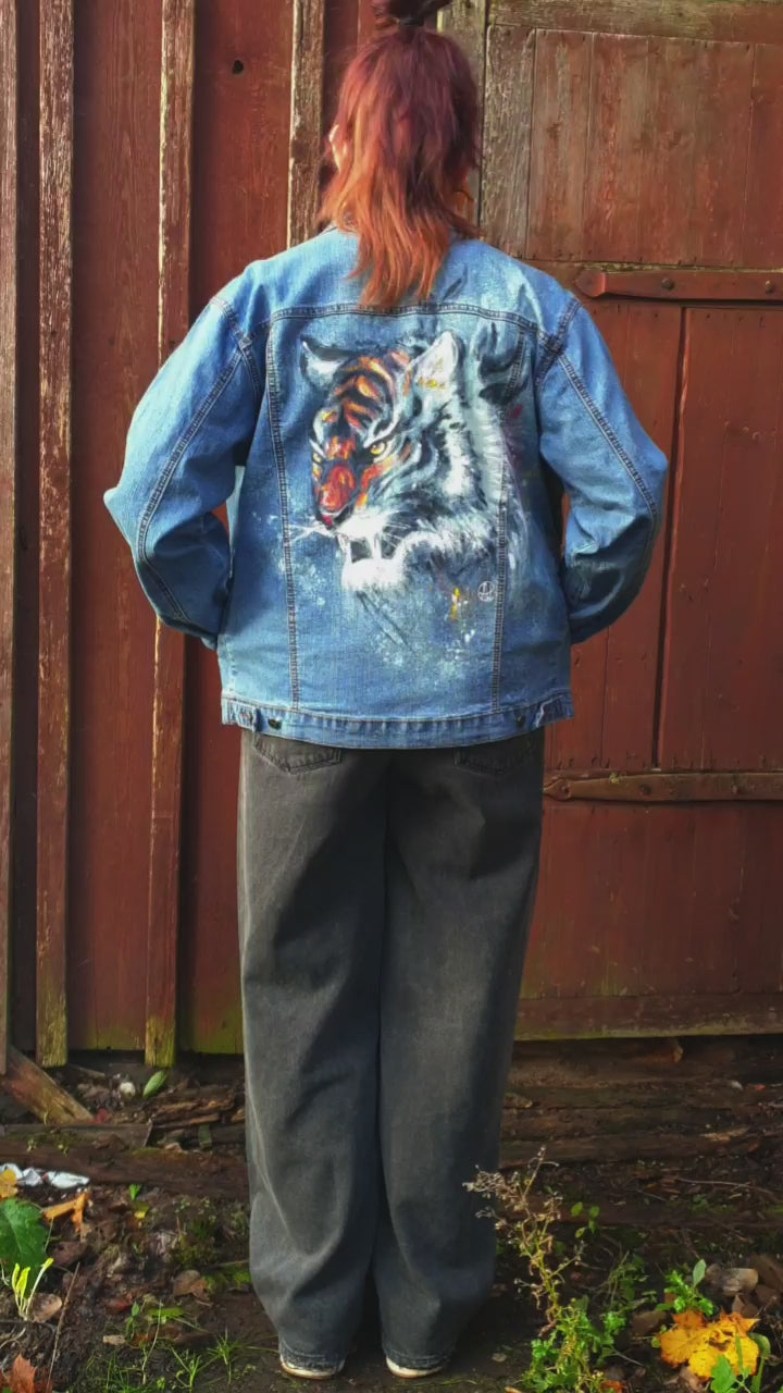 Close-up of the tiger artwork showing vivid color and bleach contrast on denim. model view