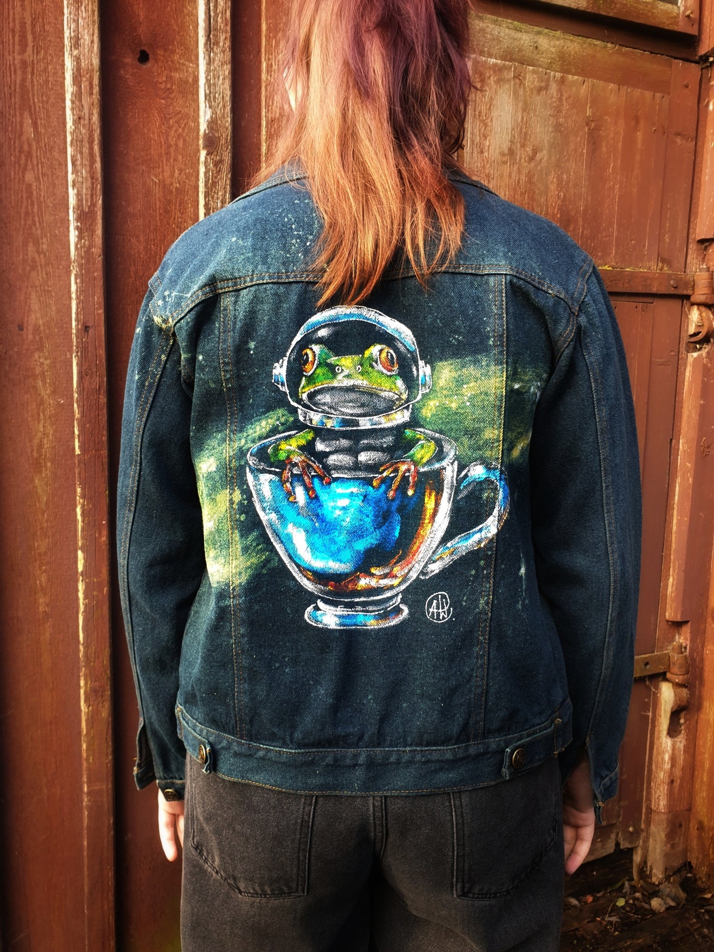 Back view of one-of-a-kind hand-painted denim jacket featuring frog astronaut design – Hele Artwear.